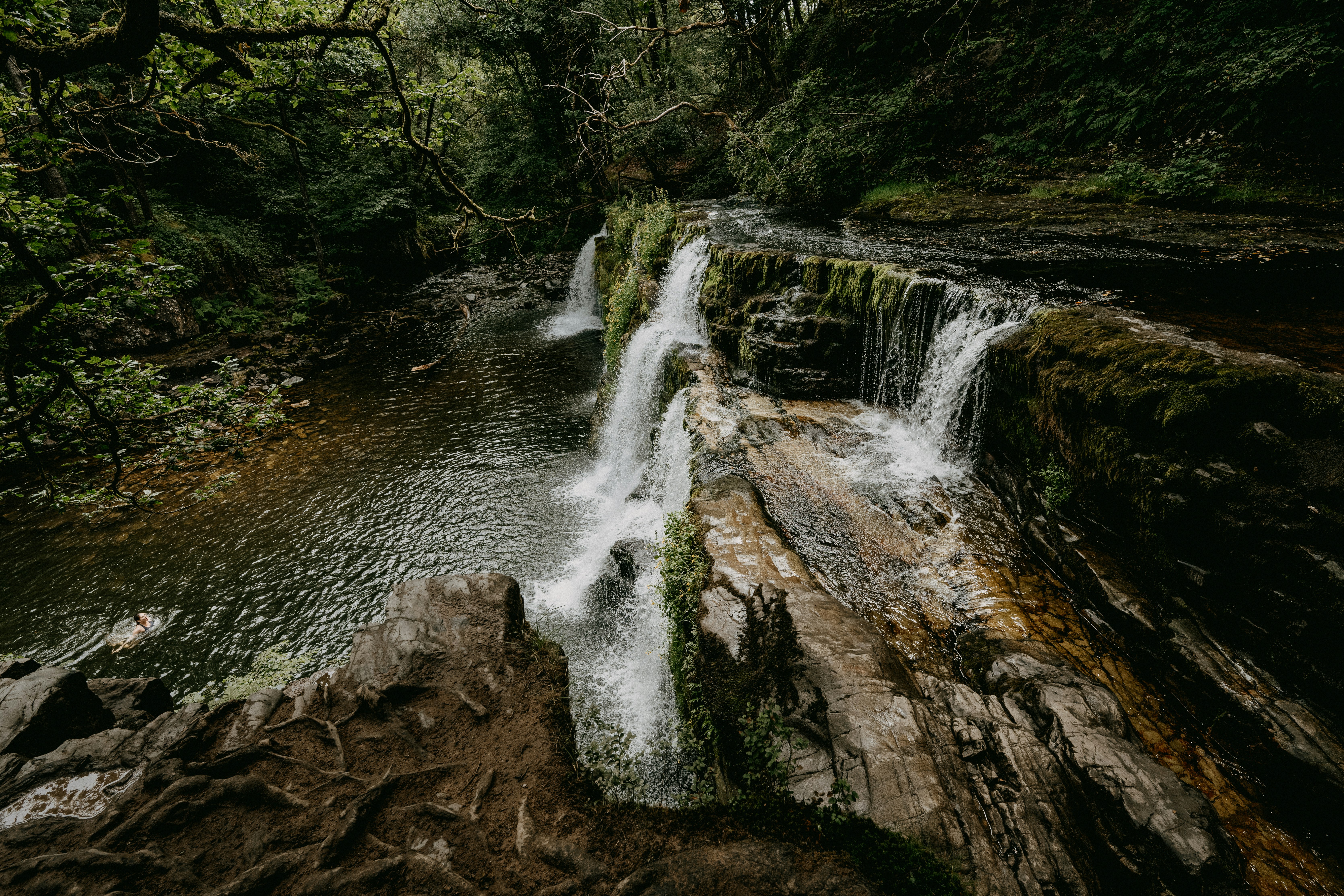 water falls on brown rocky mountain